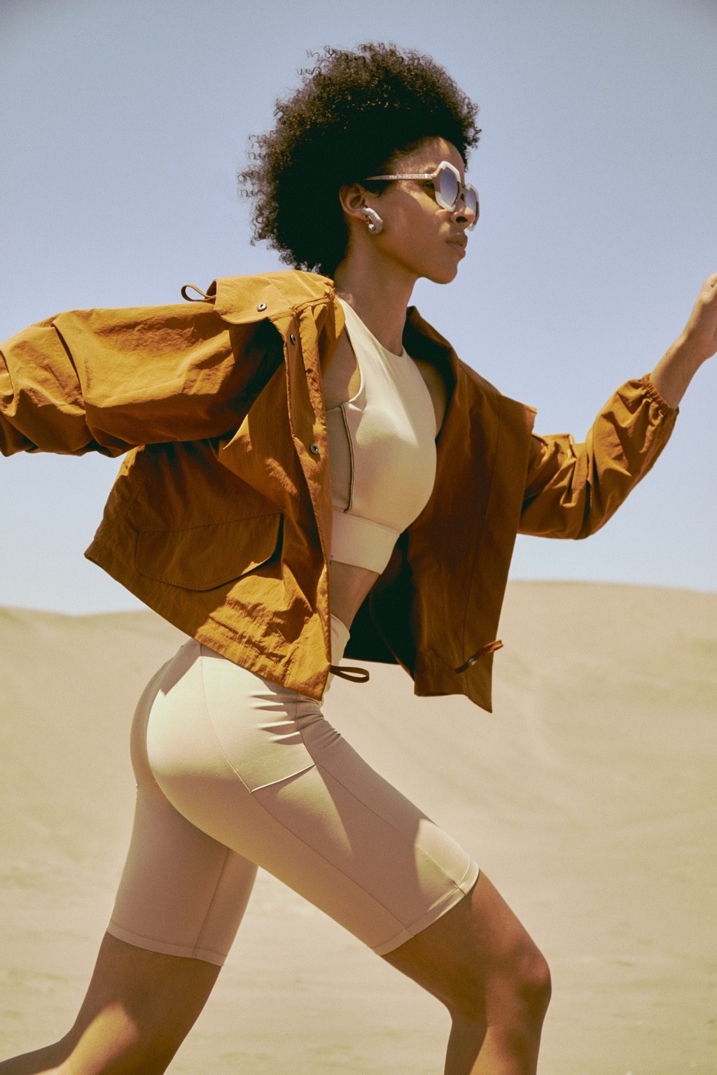 Mónica con chaqueta ocre y lentes de sol en las dunas